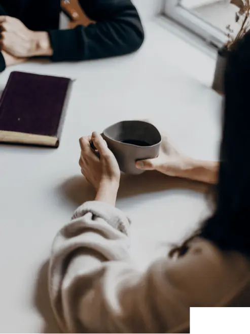 Women Holding Cup of Coffee on White Table