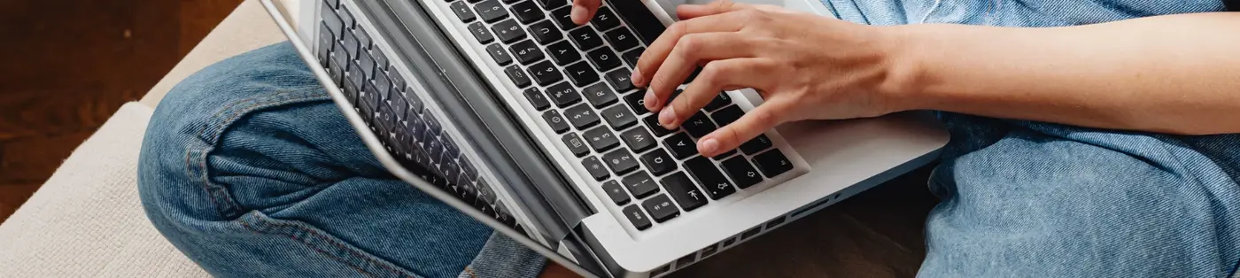 Banner showing a woman on a sofa using a laptop to find low-cost therapy options online