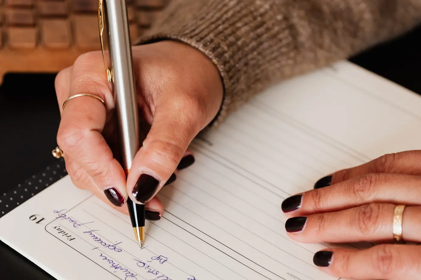 Woman at desk writing a to-do list to manage tasks and improve focus, illustrating ADHD support strategies.